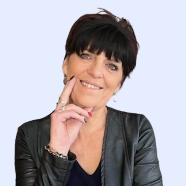 Une femme portant une veste en cuir noire posant avec son doigt sur son menton.
